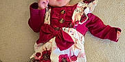 Elya participe au concours pour gagner de l'argent avec cette photo : baby, bow, carpet, child, clothing, cute, face, floral_outfit, hand, happy, indoor, infant, leg, pattern, person, pink, red, skin, smiling, tattoo