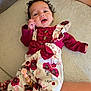 baby, bow, carpet, child, clothing, cute, face, floral_outfit, hand, happy, indoor, infant, leg, pattern, person, pink, red, skin, smiling, tattoo