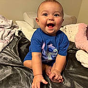 Rose Nicole joined the competition — help win amazing prizes! baby, bed, blanket, blue_shirt, cartoon_character, child, cozy, cute, expression, foot, hand, happy, indoors, infant, person, room, sitting, skin, smiling, soft_texture