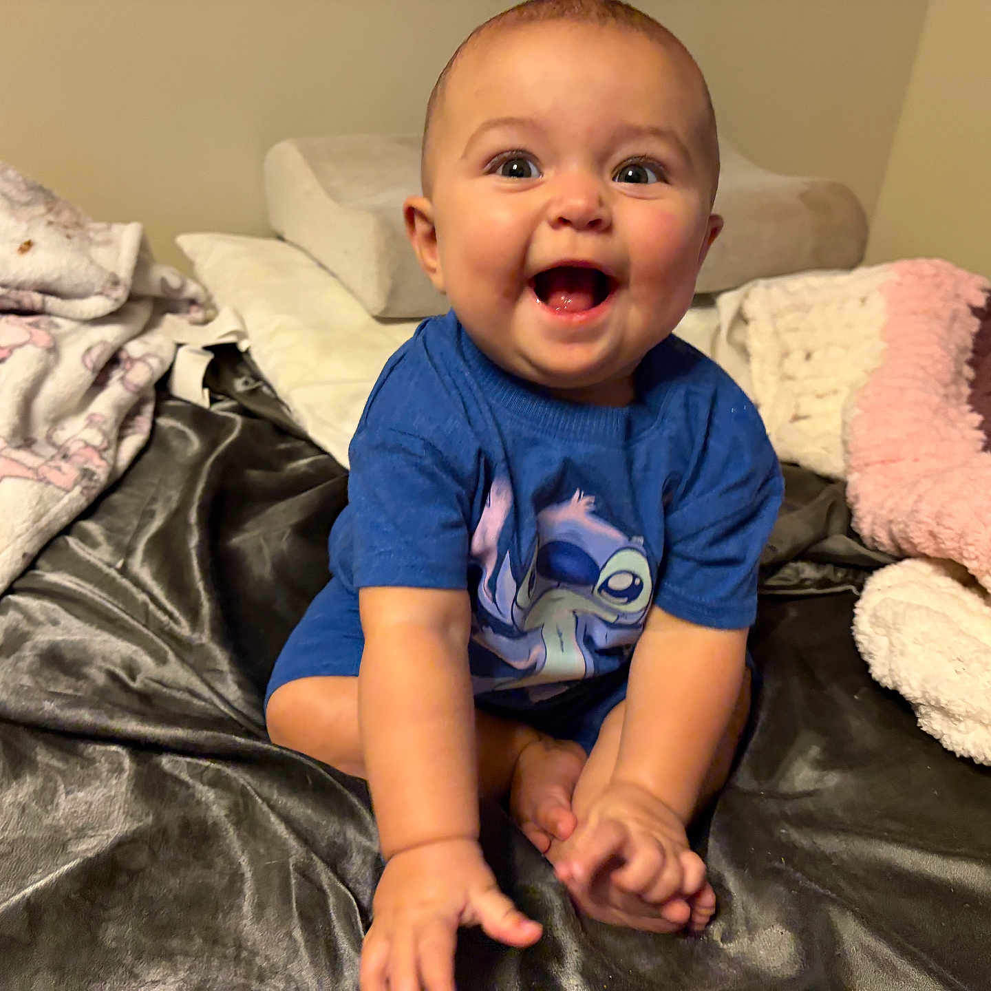Rose Nicole joined the competition — help win amazing prizes! baby, bed, blanket, blue_shirt, cartoon_character, child, cozy, cute, expression, foot, hand, happy, indoors, infant, person, room, sitting, skin, smiling, soft_texture