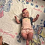 baby, girl, smiling, blanket, princess, overalls, headband, bow, numbers, months, cartoon, character, lying_down, happy, cute, indoor, carpet, feet, child, portrait