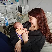 Sohan participe au concours pour gagner de l'argent avec cette photo : newborn, baby, woman, hospital_room, hospital_bed, bassinet, medical_monitor, blanket, holding, smile, portrait, indoor, parenthood, care, love, sweater, long_hair, skin, furniture, device