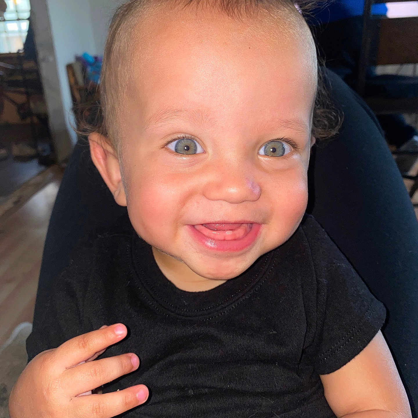 Tyler Garner is registered to the contest to win money with this photo: baby, black_shirt, cheerful, child, cute, expression, eyes, face, hair, hand, happy, home, indoor, infant, person, portrait, sitting, skin, smiling, toddler