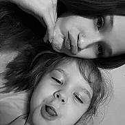 Delilah joined the competition — help win amazing prizes! black_and_white, child, close_up, dark_hair, decorations, faces, family, floral_dress, funny_face, girl, grayscale, indoors, long_hair, mother, photography, portrait, selfie, tongue_out, wall, young_child