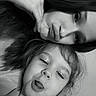black_and_white, child, close_up, dark_hair, decorations, faces, family, floral_dress, funny_face, girl, grayscale, indoors, long_hair, mother, photography, portrait, selfie, tongue_out, wall, young_child