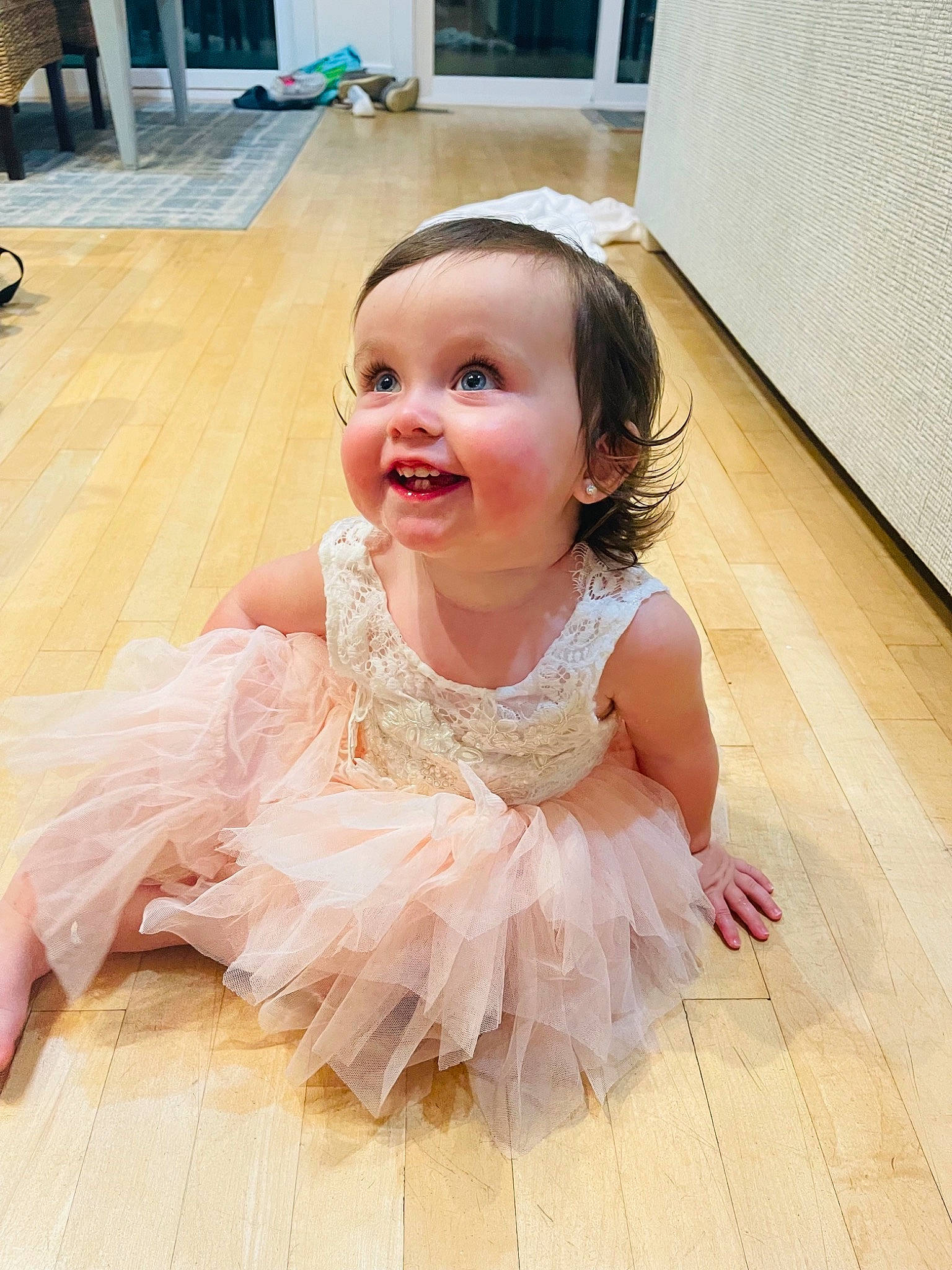 Tillie is registered to the contest to win money with this photo: baby, baby_toddler_clothing, child, dress, embellishment, event, floor, flooring, fun, happy, hardwood, headpiece, iris, person, picture_frame, pink, ruffle, skin, smile, toddler