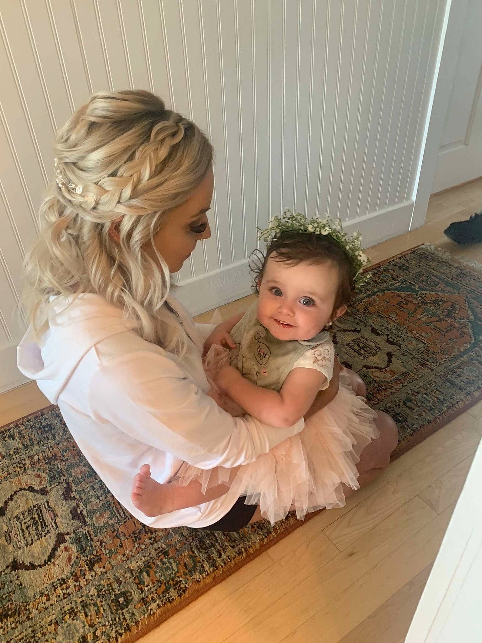 Tillie is registered to the contest to win money with this photo: arm, blond, chair, comfort, dress, eye, floor, flooring, hair, hairstyle, happy, hardwood, head, laminate_flooring, long_hair, person, shoulder, sitting, toddler, wood