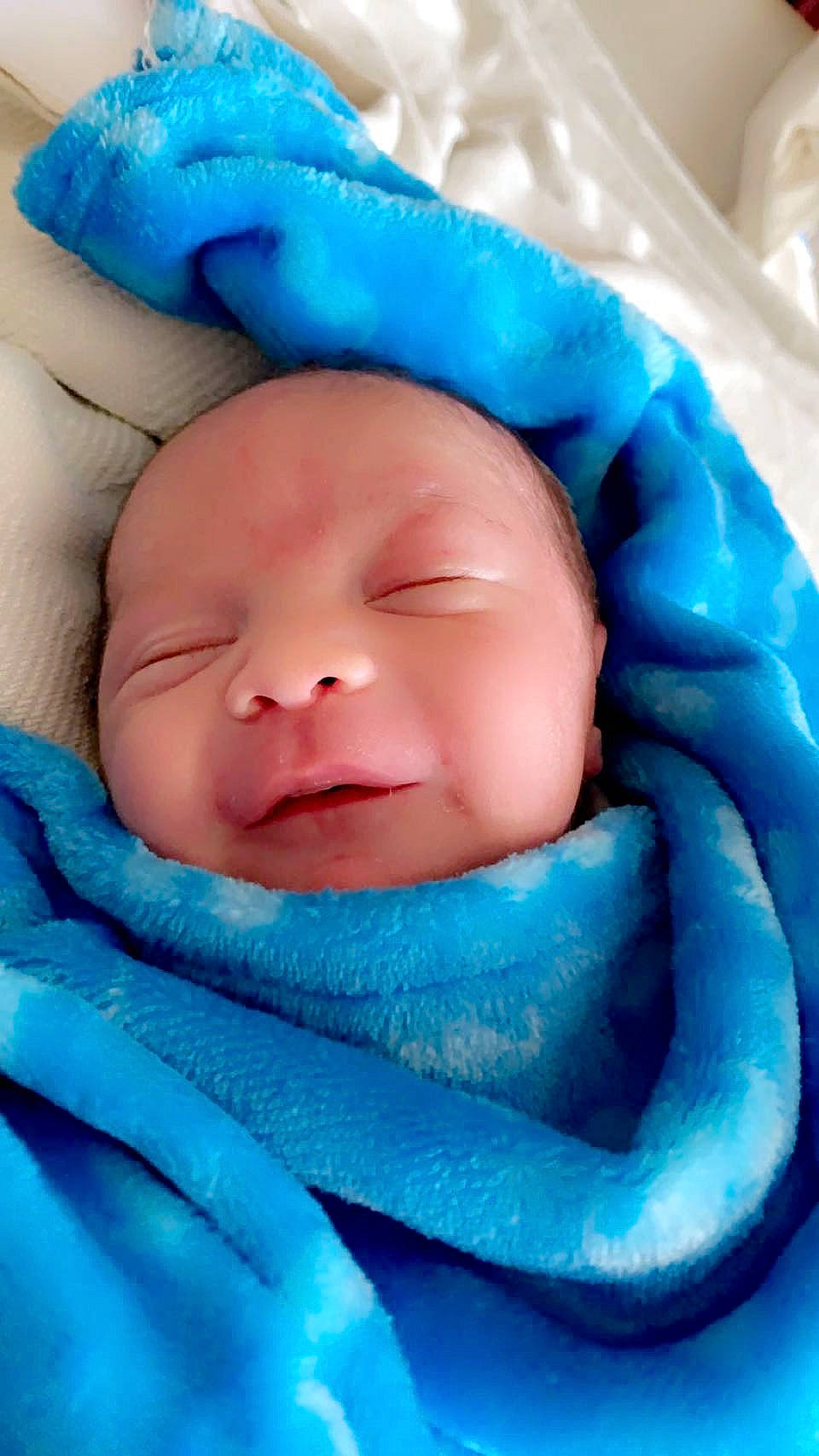 John is registered to the contest to win money with this photo: aqua, baby, baby_products, baby_sleeping, baby_toddler_clothing, blue, cheek, child, comfort, electric_blue, eyebrow, happy, headgear, iris, linens, mouth, nose, person, skin, smile