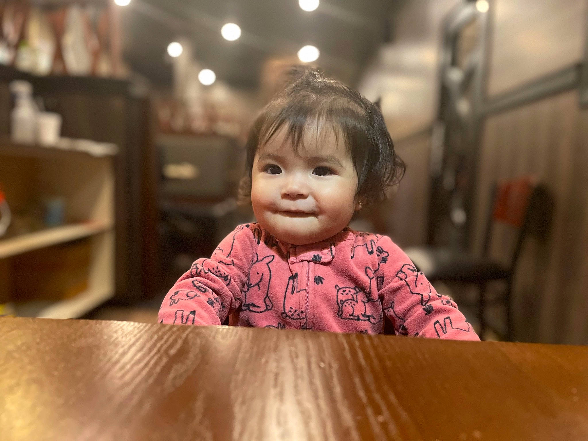 Camilla is registered to the contest to win money with this photo: cheek, child, facial_expression, flash_photography, flooring, fun, hairstyle, happy, hardwood, human_body, leisure, lip, nose, person, skin, smile, table, toddler, varnish, wood