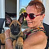 woman, dog, puppy, outdoor, chair, sunglasses, swimsuit, red_hair, smiling, holding, summer, window, reflection, black_chair, pet, animal, skin, freckles, earrings, relaxed