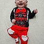 baby, smiling, infant, red_bow_tie, red_pants, heart_design, black_shirt, white_blanket, lying_down, cute_outfit, happy, child, valentine, baby_clothing, portrait, one_person, indoors, soft_texture, red_and_black, infant_smile