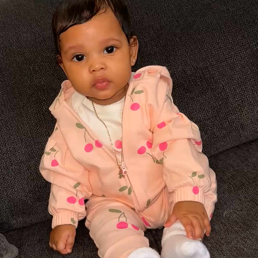 Allani joined the competition — help win amazing prizes! baby, black_hair, cherry_print, child, clothing, couch, cute, expression, face, hand, hoodie, indoors, infant, jacket, necklace, person, portrait, sitting, socks, sofa