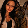 Aka participe au concours pour gagner de l'argent avec cette photo : woman, dog, portrait, indoor, closeup, black_hair, brown_eyes, long_hair, sweater, canine, pet, companion, looking_at_camera, face, animal, friendship, warm_lighting, tattoo, serious_expression, cuddling