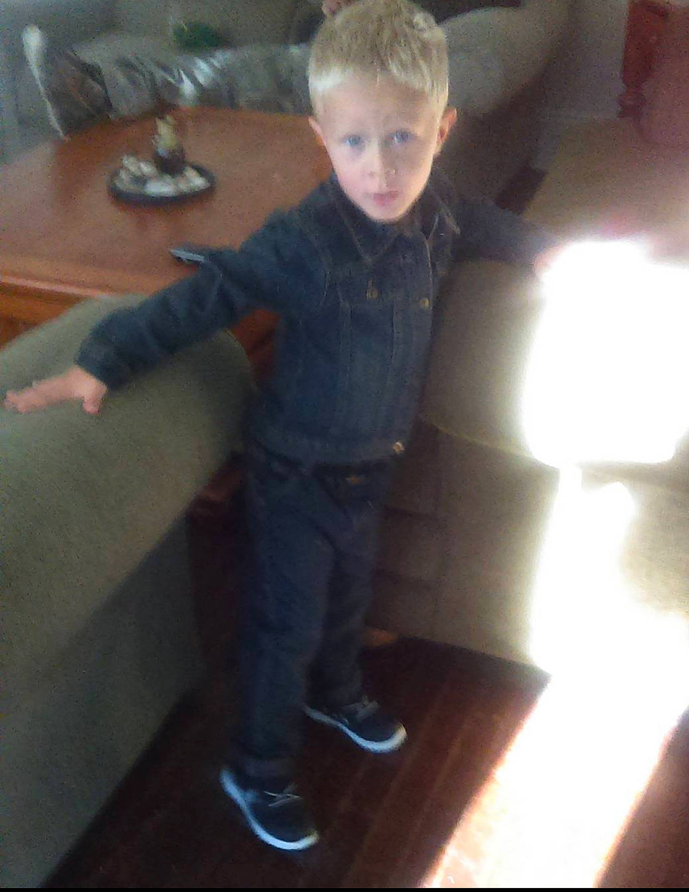 Kolton is registered to the contest to win money with this photo: child, cool, denim, elbow, electric_blue, electronic_device, finger, floor, flooring, fun, hardwood, person, room, sitting, sleeve, sneakers, t_shirt, table, thumb, toddler