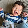 Aylan a rejoint le concours — aidez-le/la à gagner de superbes lots ! baby, child, smiling, laughing, striped_clothing, blue_and_white, text_on_clothing, onesie, toddler, happy, indoor, blanket, denim, person, face, hair, cute, infant, hand, lying_down