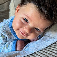 Aylan a rejoint le concours — aidez-le/la à gagner de superbes lots ! baby, infant, smile, face, hair, onesie, blanket, couch, texture, indoors, cute, child, lying_down, portrait, happy, skin, blue, cozy, soft, expression