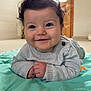 Aylan a rejoint le concours — aidez-le/la à gagner de superbes lots ! baby, child, smiling, curly_hair, lying_down, play_mat, indoor, sweater, face, happy, person, floor, door, light, home, cozy, infant, cute, portrait, hands