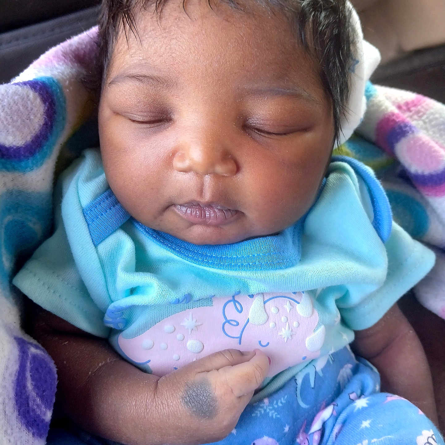 Korriana is registered to the contest to win money with this photo: baby, sleeping, infant, blanket, blue_clothing, dinosaur_pattern, hand, face, peaceful, cute, newborn, soft_lighting, indoor, closeup, child, wrapped, cozy, portrait, skin, head