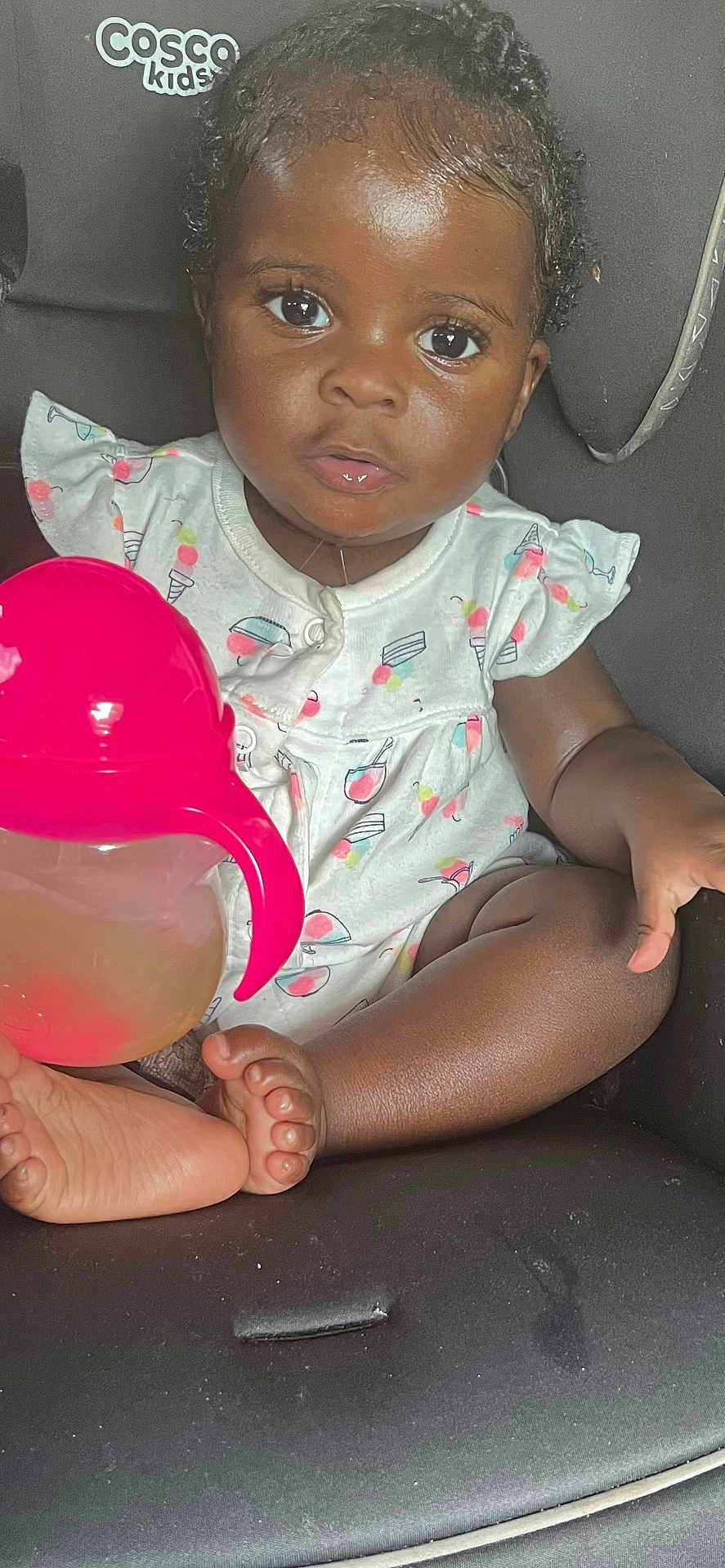 Mulan joined the competition — help win amazing prizes! toddler, child, car_seat, sippy_cup, pink, white_clothing, ice_cream_pattern, cherry_pattern, curly_hair, barefoot, indoors, seat_belt, person, cute, baby, young_child, skin, face, eyes, hand