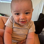 Tristan joined the competition — help win amazing prizes! baby, child, smile, face, eyes, arm, indoor, window, blinds, person, clothing, sitting, skin, hand, comfort, cute, expression, young, head, portrait