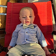 Tristan joined the competition — help win amazing prizes! baby, child, bow_tie, checkered_shirt, pants, red_chair, sunlight, shadow, relaxed, cute, portrait, indoor, seat, fashion, smile, infant, clothing, person, baby_boy, casual