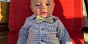 Tristan joined the competition — help win amazing prizes! baby, child, bow_tie, checkered_shirt, pants, red_chair, sunlight, shadow, relaxed, cute, portrait, indoor, seat, fashion, smile, infant, clothing, person, baby_boy, casual
