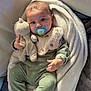 Eyden participe au concours pour gagner de l'argent avec cette photo : baby, infant, pacifier, stuffed_animal, blanket, bib, onesie, couch, sofa, seated, portrait, cozy, soft_texture, looking_at_camera, hand, feet, indoor, nursery, adorable, cute