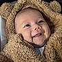 baby, blue_eyes, children, chubby_cheeks, close_up, cozy, cute, face, fuzzy_jacket, happy, hood, indoor, infant, portrait, seated, smiling, soft_texture, teddy_bear_hood, warm_clothing, zipper