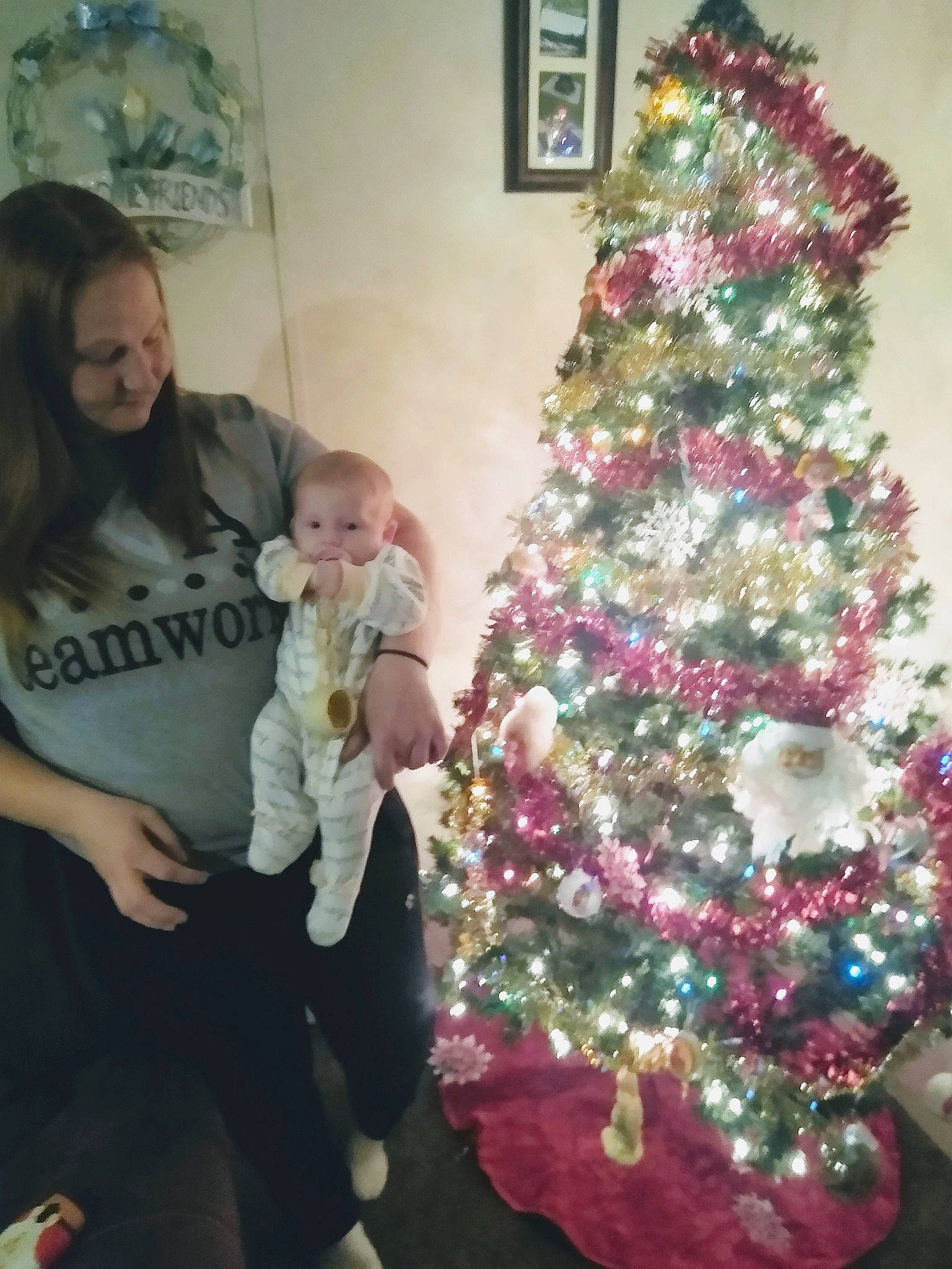 Meadow is registered to the contest to win money with this photo: baby, baby_toddler_clothing, christmas, christmas_decoration, christmas_eve, christmas_lights, christmas_ornament, christmas_tree, event, holiday, holiday_ornament, home, human, interior_design, nose, ornament, person, picture_frame, pink, toddler