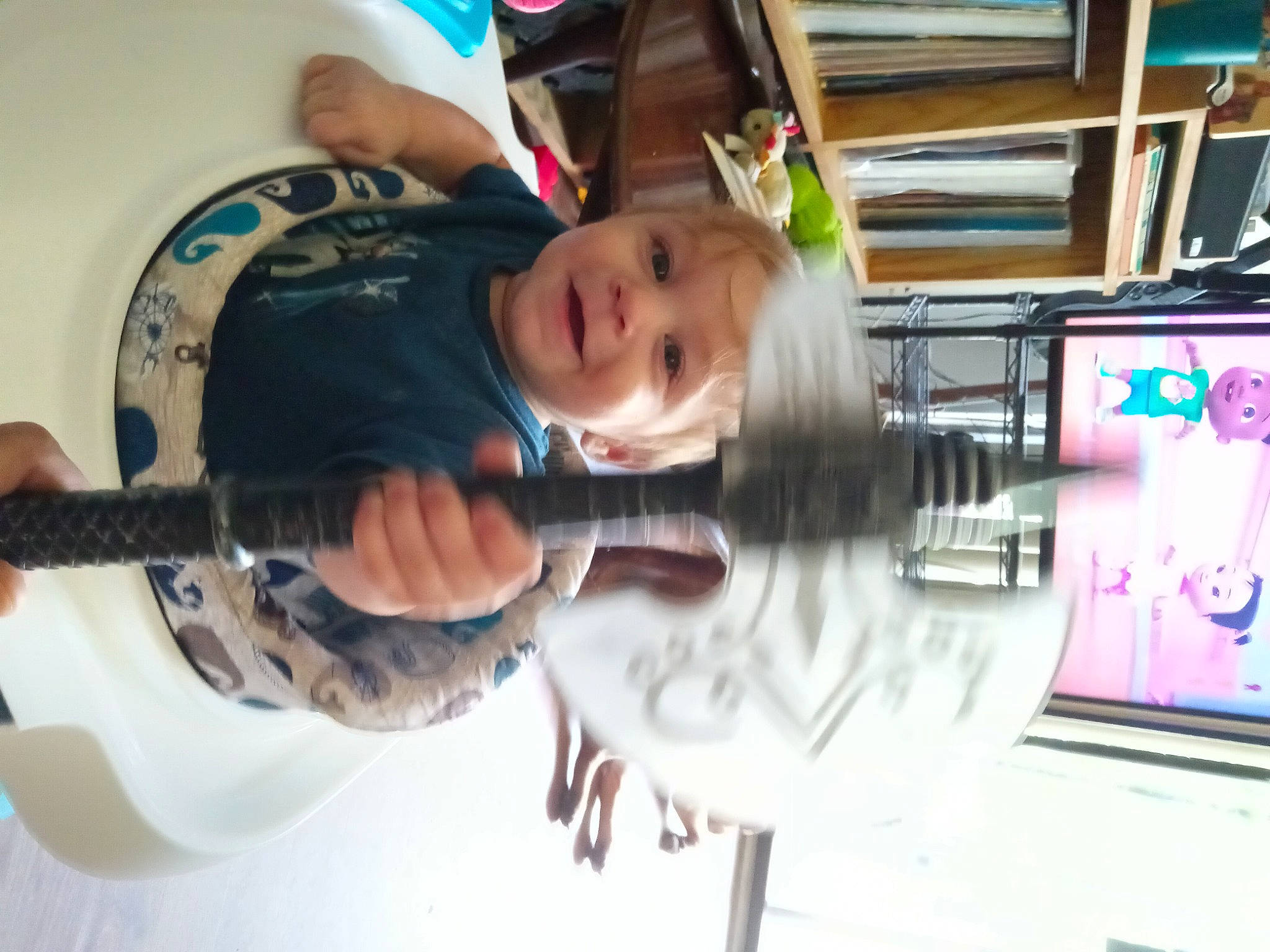 Joey is registered to the contest to win money with this photo: baby, birthday_cake, cake, chair, child, food, fun, hat, joy, leisure, machine, musical_instrument, person, play, plucked_string_instruments, recreation, room, smile, t_shirt, toddler