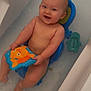baby, bath_seat, bath_time, bathtub, blue, child, face, fish_toy, happy, head, indoors, orange, person, playing, skin, smiling, splashing, toy, water, water_toy