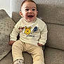 Raphaël a rejoint le concours — aidez-le/la à gagner de superbes lots ! baby, child, smiling, sitting, couch, clothing, socks, face, happy, indoors, cute, infant, sweater, pants, person, apparel, cozy, home, portrait, young