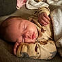 Beau is registered to the contest to win money with this photo: baby, sleeping, blanket, onesie, infant, cozy, cute, peaceful, face, hand, soft_lighting, bed, rest, child, portrait, indoors, warm, comfort, newborn, relaxation