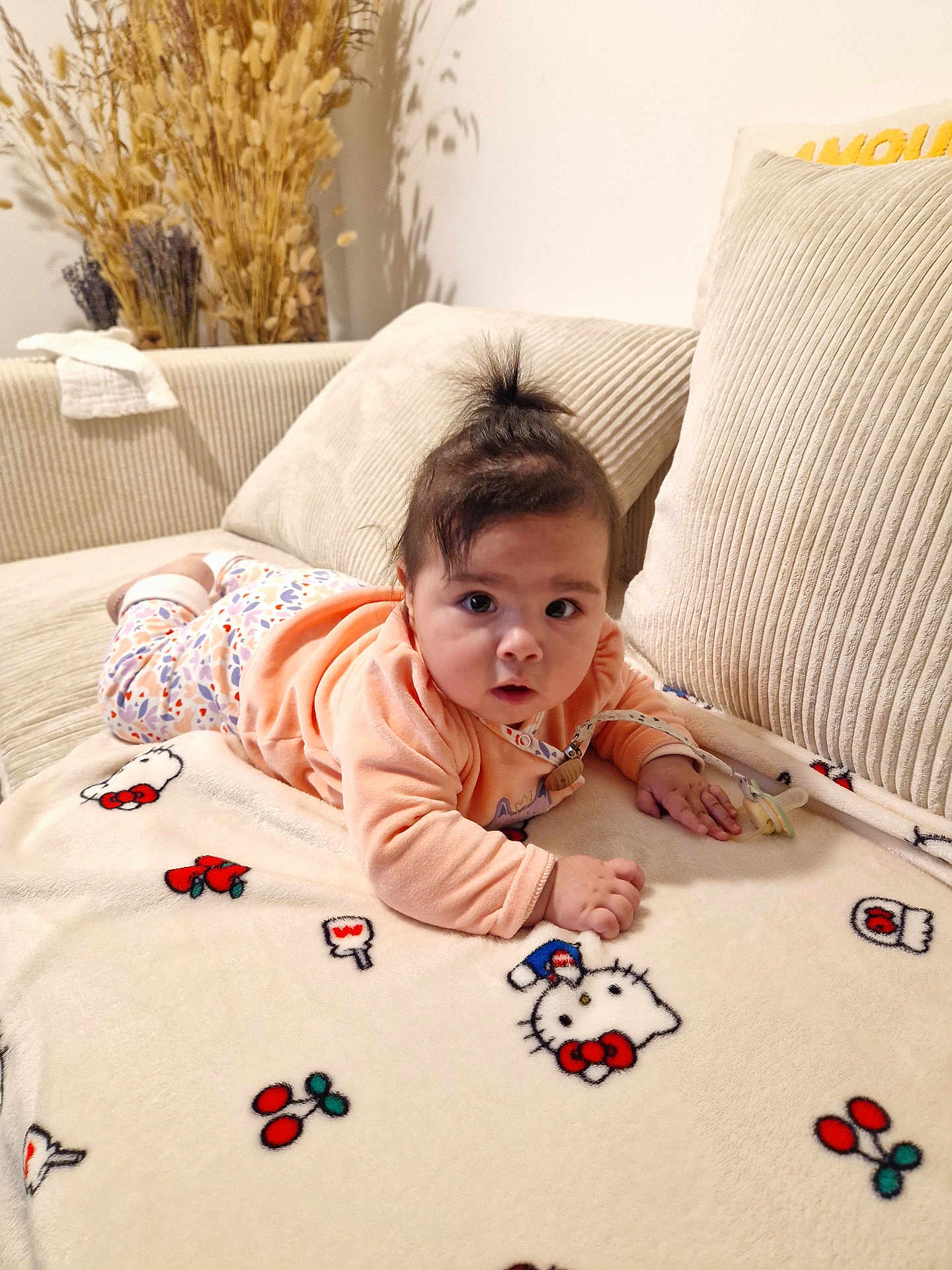 Alessandra a rejoint le concours — aidez-le/la à gagner de superbes lots ! baby, blanket, child, couch, cozy, curious, cute, expression, face, hair, hello_kitty, home, indoors, infant, lying_down, pacifier, pajamas, pillow, soft_furniture, toddler