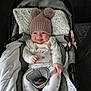 baby, smiling, hat, pom_poms, car_seat, onesie, infant, cute, cozy, child, happy, indoor, blanket, clothing, seatbelt, comfort, portrait, person, headwear, warm
