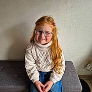 Alice participe au concours pour gagner de l'argent avec cette photo : casual_clothing, child, cozy, floor, girl, glasses, hands, happy, home, indoor, jeans, long_hair, ottoman, portrait, red_hair, sitting, slippers, smile, sweater, wall