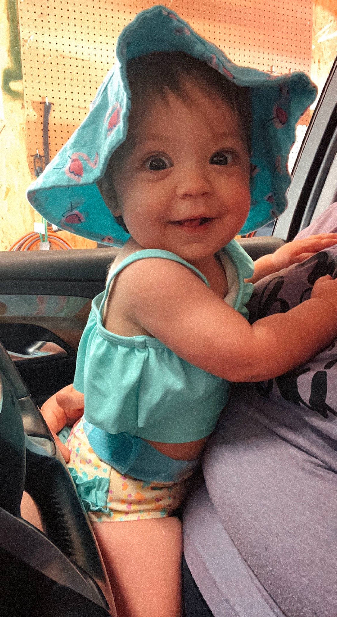 Mckinley is registered to the contest to win money with this photo: car_seat, child, chin, eye, face, fun, happy, head, joy, leisure, mode_of_transport, motor_vehicle, mouth, neck, person, skin, smile, snapshot, steering_wheel, thigh