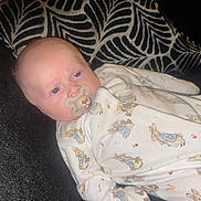 Riley-Jay is registered to the contest to win money with this photo: baby, pacifier, onesie, bunny_pattern, couch, pillow, infant, sleepwear, child, face, head, lying_down, comfort, indoor, soft_toys_pattern, cute, small_child, young_baby, resting, calm