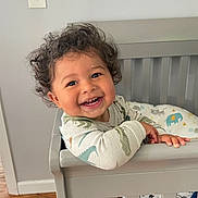 Crew joined the competition — help win amazing prizes! toddler, child, crib, smiling, curly_hair, onesie, dinosaur_print, baby, indoor, wooden_floor, bedding, animal_print, happy, face, person, furniture, home, cute, playful, standing