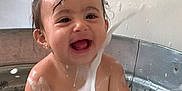 Raven is registered to the contest to win money with this photo: baby, child, bath, metal_tub, water, soap, bubbles, splash, happy, smile, wet_hair, indoor, playful, fun, face, skin, cute, joy, toddler, clean