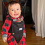 Raven is registered to the contest to win money with this photo: baby, child, smiling, jolly_jumper, red_checkered_clothing, indoor, wooden_floor, curtain, happy, playtime, onesie, infant, face, person, home, furniture, toy, floor, cute, joyful
