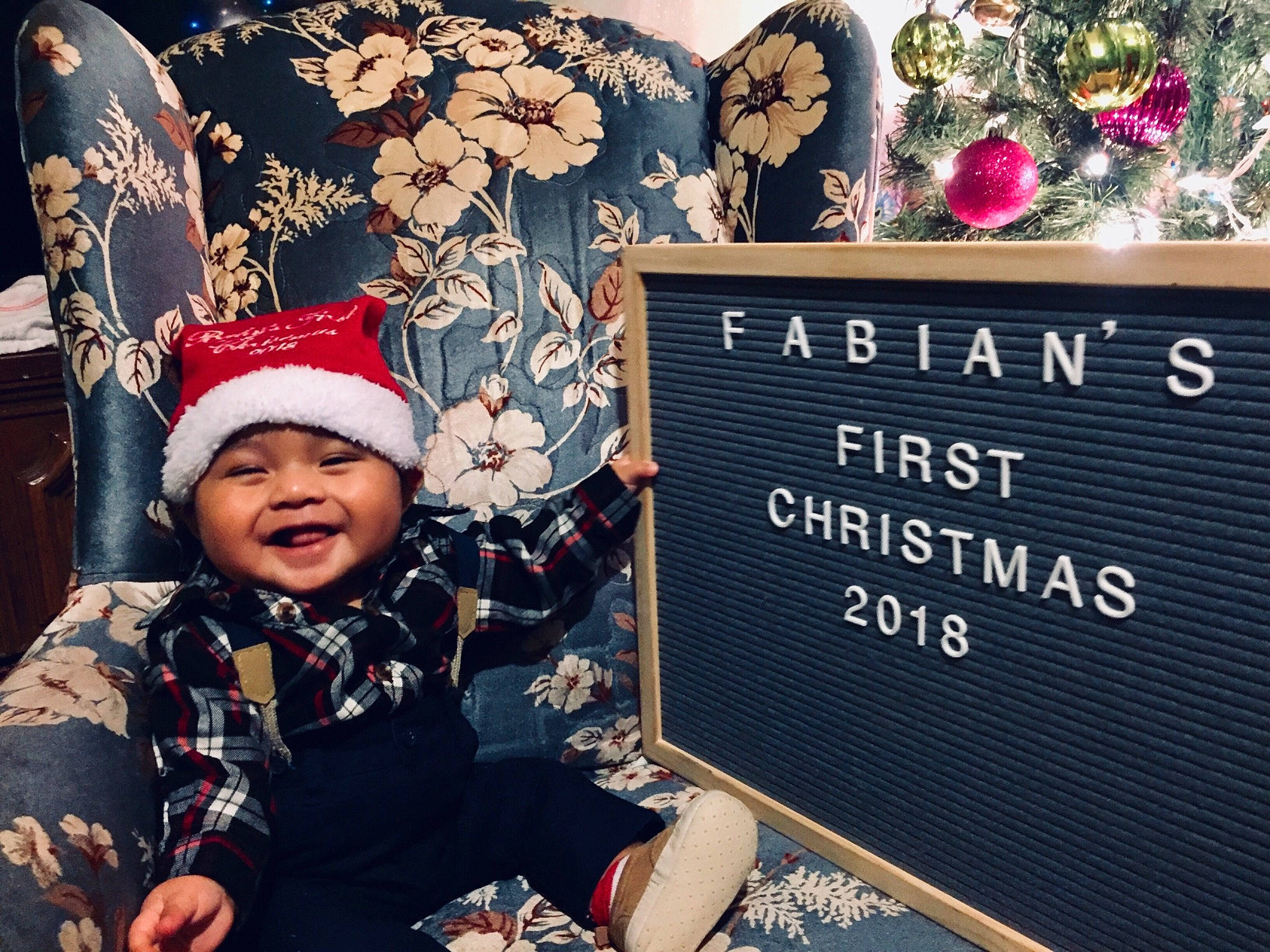 Fabian is registered to the contest to win money with this photo: child, christmas, christmas_eve, fictional_character, happy, headgear, headwear, holiday, joy, people, person, plant, smile, toddler, winter