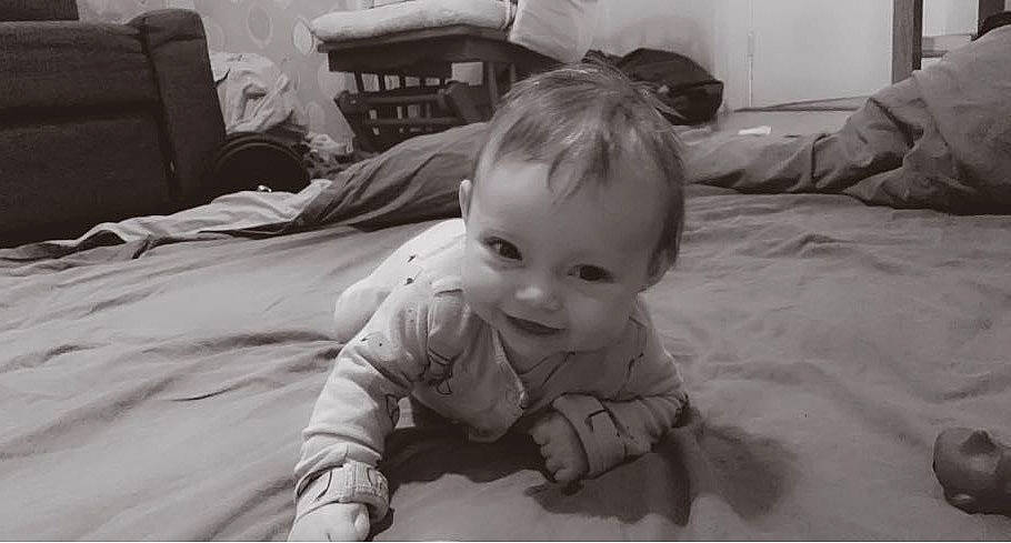 Lyra is registered to the contest to win money with this photo: baby, cheek, child, comfort, crawling, eye, face, flash_photography, flooring, fun, happy, head, iris, joy, linens, monochrome_photography, person, room, sitting, smile
