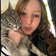Nala participe au concours pour gagner de l'argent avec cette photo : animal, casual_clothing, cat, close_up, cute, expression, face, feline, hair, hand, holding, human, indoor, looking_at_camera, natural_light, pet, portrait, selfie, tabby_cat, woman