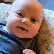 Richard joined the competition — help win amazing prizes! baby, infant, child, smile, face, cheeks, eyes, hand, pillow, blanket, pattern, clothing, onesie, portrait, closeup, indoor, cuddly, happy, skin, head