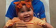 Liam joined the competition — help win amazing prizes! child, baby, smile, happy, boy, girl, sibling, portrait, clothing, headband, orange, blue_shirt, holding, seated, indoor, cute, family, toddler, hands, background