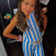 Lyric is registered to the contest to win money with this photo: child, girl, striped_clothing, blue, white, knitwear, long_hair, scrunchie, refrigerator, drawings, handmade_art, wooden_floor, indoor, home, pose, smile, cabinet, childrens_art, note, casual