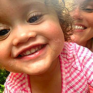 Lydiah is registered to the contest to win money with this photo: child, toddler, smiling, curly_hair, face, person, adult, close_up, portrait, pink_striped_shirt, outdoor, daylight, happy, family, cute, young_child, skin, eyelashes, teeth, nature