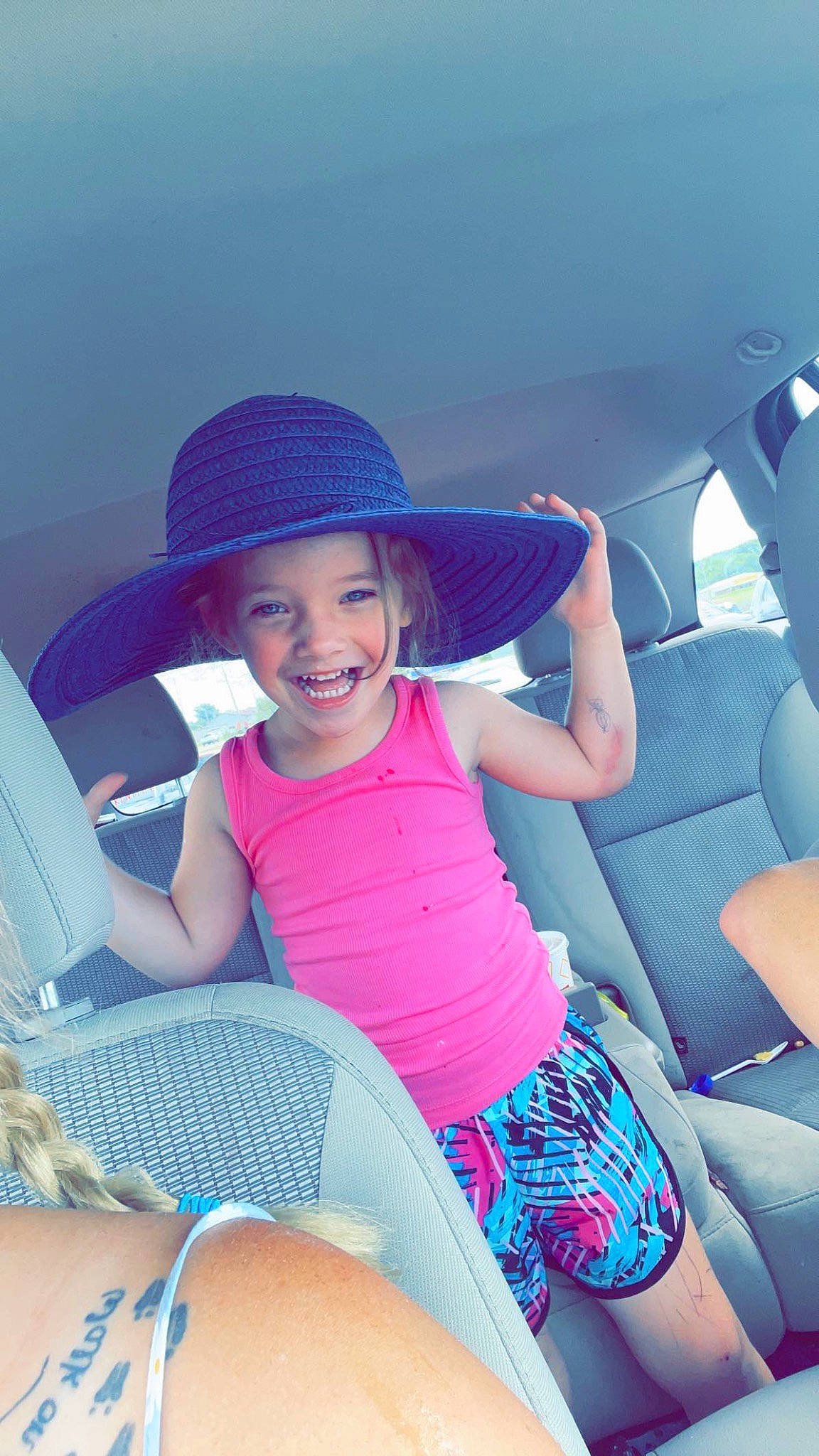 Braelyn is registered to the contest to win money with this photo: automotive_design, azure, cap, comfort, electric_blue, flash_photography, happy, hat, headgear, headwear, joy, knee, leg, leisure, motor_vehicle, person, pink, shorts, smile, sun_hat