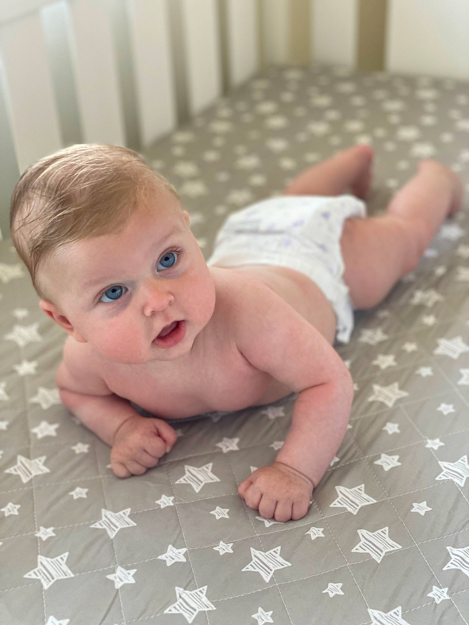Aren is registered to the contest to win money with this photo: baby, baby_crawling, baby_toddler_clothing, cheek, child, comfort, finger, floor, flooring, foot, fun, hand, happy, hardwood, linens, nail, person, sitting, skin, surprise